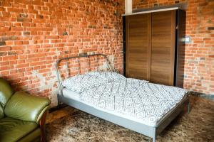 een bed in een kamer met een bakstenen muur bij RedCity Loft 25 in Żyrardów