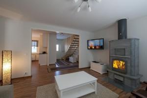 sala de estar con chimenea y TV en Kajaani Cottages, en Jormua