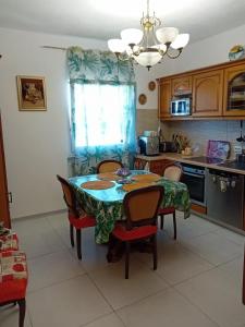 cocina con mesa, sillas y mesa en Casa di Vacanza, en Porto Tolle
