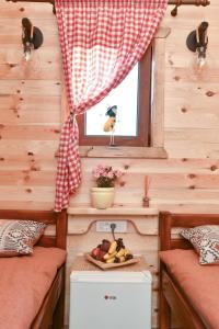 een tiny house met een raam en een tafel met fruit bij Cottages Big bear in Žabljak