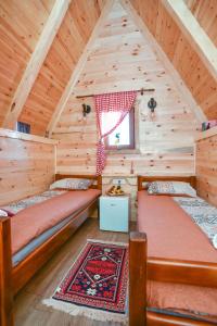 a bedroom with two beds in a log cabin at Cottages Big bear in Žabljak