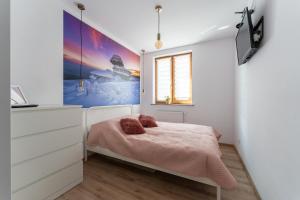 a bedroom with a bed with pink sheets and a window at Apartament Strumykowy Zakątek - w centrum z prywatnym parkingiem - Space Apart in Karpacz