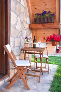 a table with two chairs and a bottle of wine at Cottages Big bear in Žabljak