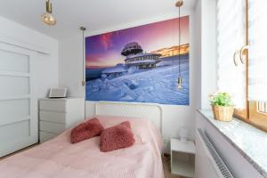 a bedroom with a pink bed with a picture on the wall at Apartament Strumykowy Zakątek - w centrum z prywatnym parkingiem - Space Apart in Karpacz