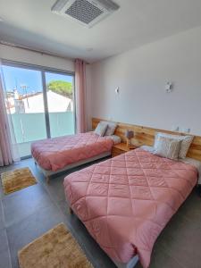 a bedroom with two beds and a large window at Villa Luz 37 - Jacuzzi Terrace & Swimming Pool in Albufeira