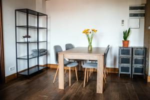 a dining room table with chairs and a vase of flowers at RedCity Loft 25 in Żyrardów