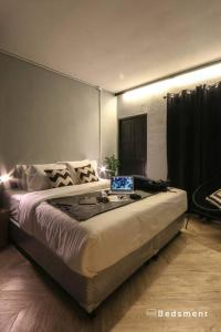 1 dormitorio con 1 cama con ordenador portátil en Bedsment@Hayaek, en Chiang Rai