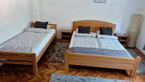 two beds in a room with wooden floors at House Dado in Jezerce