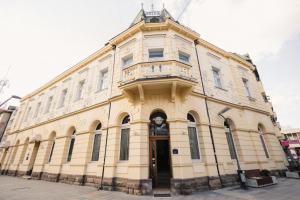 a yellow building with a balcony on top of it at Hotel Beograd in Čačak