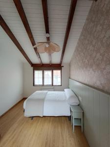 1 dormitorio con cama blanca y ventana en Casa Guadalupe en Llanes