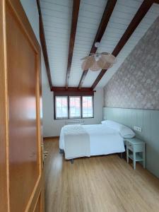 1 dormitorio con 1 cama y ventilador de techo en Casa Guadalupe, en Llanes