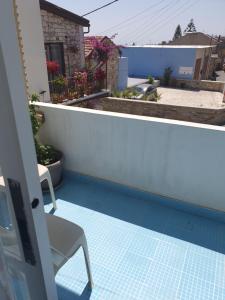 a balcony with a table and a chair on a tile floor at Indie7house in Pano Lefkara