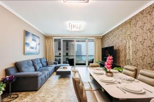 a living room with a table and a blue couch at Heart of JBR - SEA VIEW - Upgraded 3 Bedroom Suite in Dubai