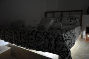 a bedroom with a bed with a black and white comforter at Smurf's house in Budva