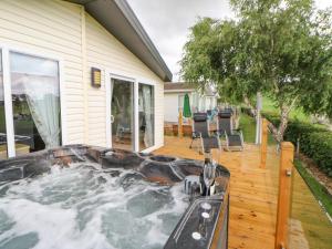 a hot tub on a deck next to a house at 36 Raven's Rest in Carlisle