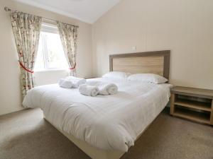 a bedroom with a large white bed with towels on it at 36 Raven's Rest in Carlisle