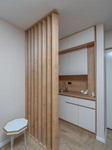 cocina con tabique de madera con fregadero y silla en Hotel Diman en Dobra Voda