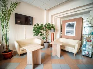 a waiting room with couches and tables and plants at Sanatorium Mewa in Kołobrzeg
