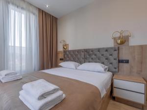 a bedroom with a large bed with towels on it at Hotel Diman in Dobra Voda
