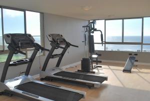 een fitnessruimte met 2 loopbanden in een kamer met ramen bij Apartamento Virgilio Arias in Antofagasta