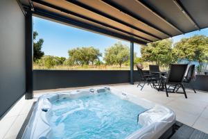 a hot tub on a patio with a table and chairs at Luxury Residence Levante in Rovinj