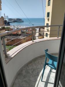 una silla azul en un balcón con vistas al océano en Durazzo Vollga 1 en Durrës
