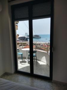 een kamer met een raam met uitzicht op de oceaan bij Durazzo Vollga 1 in Durrës