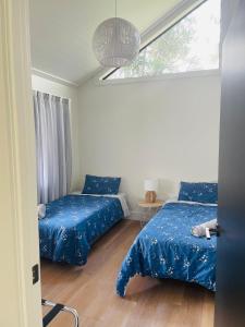 1 Schlafzimmer mit 2 Betten und einem Fenster in der Unterkunft Stunning 2 bedroom Guesthouse in Tamahere