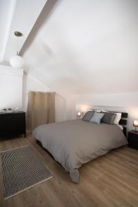 biała sypialnia z dużym łóżkiem i 2 lampami w obiekcie Isida - cozy sea walk lodge with private garden w mieście Nea Makri