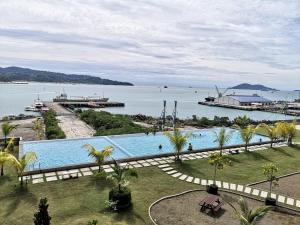 a large swimming pool next to a body of water at City View with Jesselton Quay Near Suria Sabah Mall & Jesselton Point in Kota Kinabalu