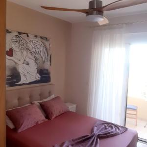 a bedroom with a bed with a painting on the wall at MARIA cozy apartments in Pigianos Kampos