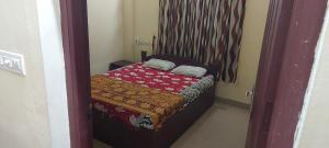 a small bedroom with a small bed with a red blanket at Adithya Residency Guruvayur in Guruvāyūr +14 photos
