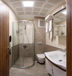 a bathroom with a shower and a toilet and a sink at Comfort Suites Hotel in Istanbul