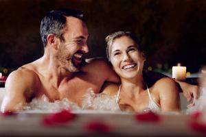 a man and a woman sitting in a bathtub at Wharton House Mews in Cartmel, Lake District in Cartmel