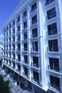 a large white building with balconies on a street at Piya Sport Hotel in Istanbul