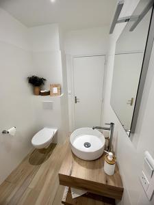 a white bathroom with a toilet and a sink at Hôtel de la Marine in Saint-Herblain