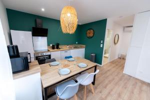 a kitchen with a table and chairs in a room at KASA ZEN - Climatisation - Tout équipé - Stationnement gratuit in Saint-Chamond +11 photos