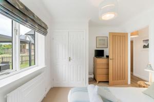 a bedroom with a bed and a window at The Hawthorns in Polzeath