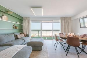 a living room with a couch and a table at Frontal seaview apartment in Blankenberge in Blankenberge
