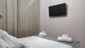 a pair of shoes sitting on a bed with a flat screen tv at Casa Vacanze Como in Como +9 photos