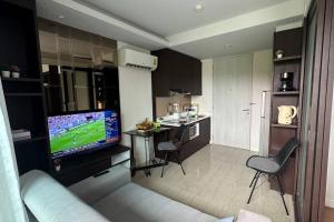 a living room with a couch and a television in a kitchen at Lovely family apartment at Surin Beach - Aristo 1, unit 203 in Ban Lum Fuang