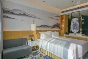 深セン市にあるPaco Hotel Shenzhen Luohu Portのベッドと椅子付きのホテルルーム