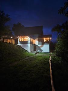 a house on top of a hill at night at City View Apartment in Bijelo Polje