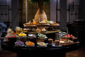 a buffet of food on a table with bowls of food at Grand Swiss-Belhotel Melaka - formerly LaCrista Hotel Melaka in Melaka