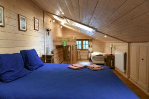 um quarto com uma cama azul num quarto de madeira em Le Vallorcin, chalet le Sizeray - Mont Blanc em Vallorcine