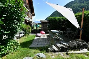 um pátio com uma mesa e um guarda-chuva branco em Le Vallorcin, chalet le Sizeray - Mont Blanc em Vallorcine