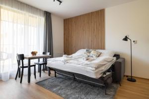 a bedroom with a bed and a table and a window at Apartmány Florián in Kvilda