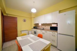 eine Küche mit einem Tisch und einem weißen Kühlschrank in der Unterkunft Apartment Ana in Zagreb