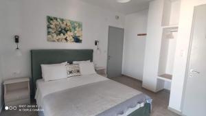 a bedroom with a bed with a green headboard at Iason studio 4 in Patitiri