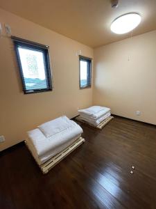 duas camas num quarto com duas janelas em On the hill ! ashitoku1 - Vacation STAY 14453 em Akaoki